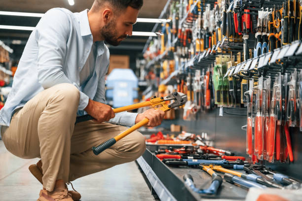 With garden shears. man is in the hardware shop.